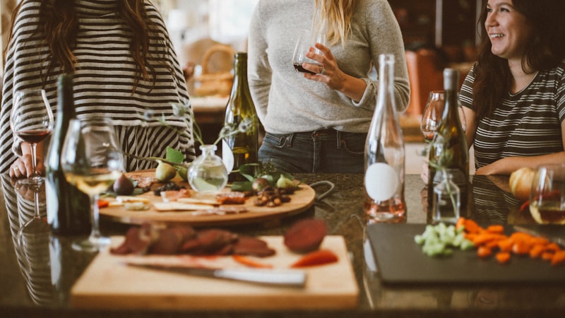 Friends laughing together over drinks and a shared board of food