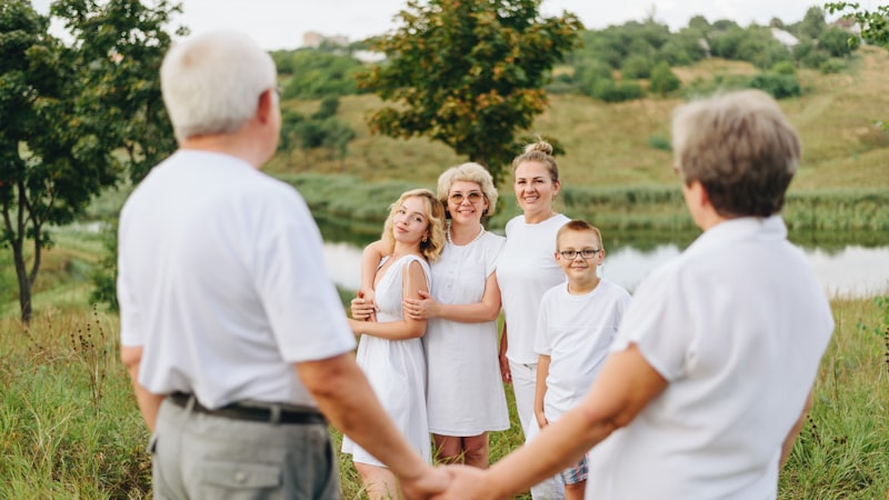 Grandparents and grandchildren holding hands in a field